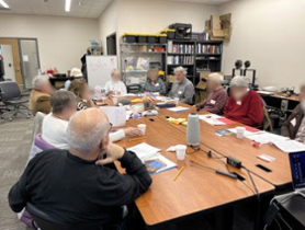 older adults sitting around a table for a discussion